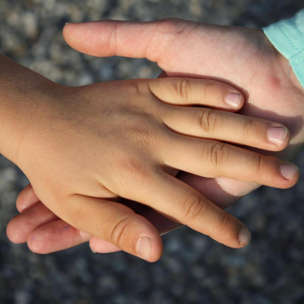 Zwei Kinderhände wovon eine in der anderen liegt