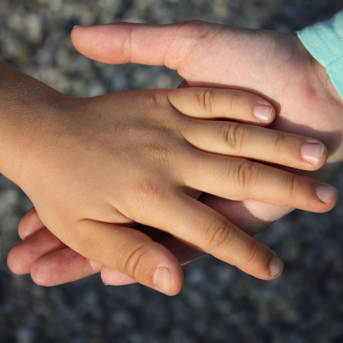 Zwei Kinderhände wovon eine in der anderen liegt