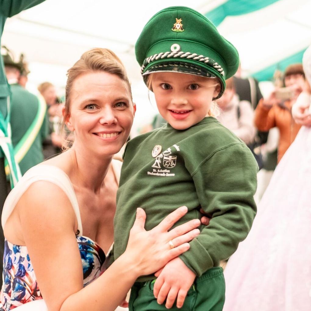Kind in Schützenuniform mit seiner Mutter