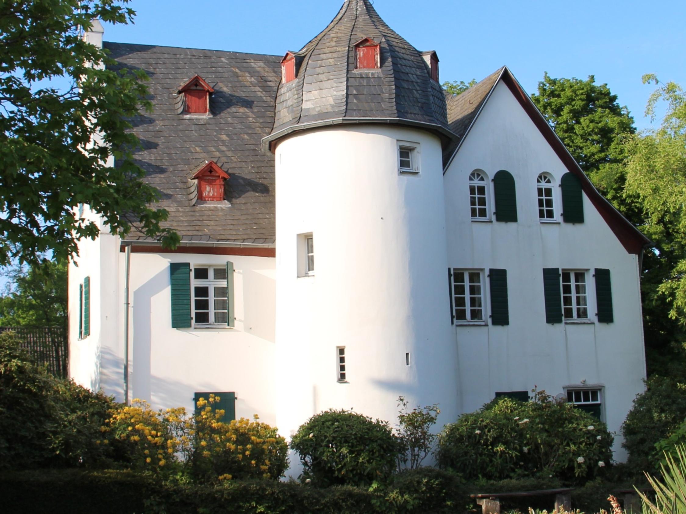 Friedenberger Hof mit Bäumen und blauem Himmel