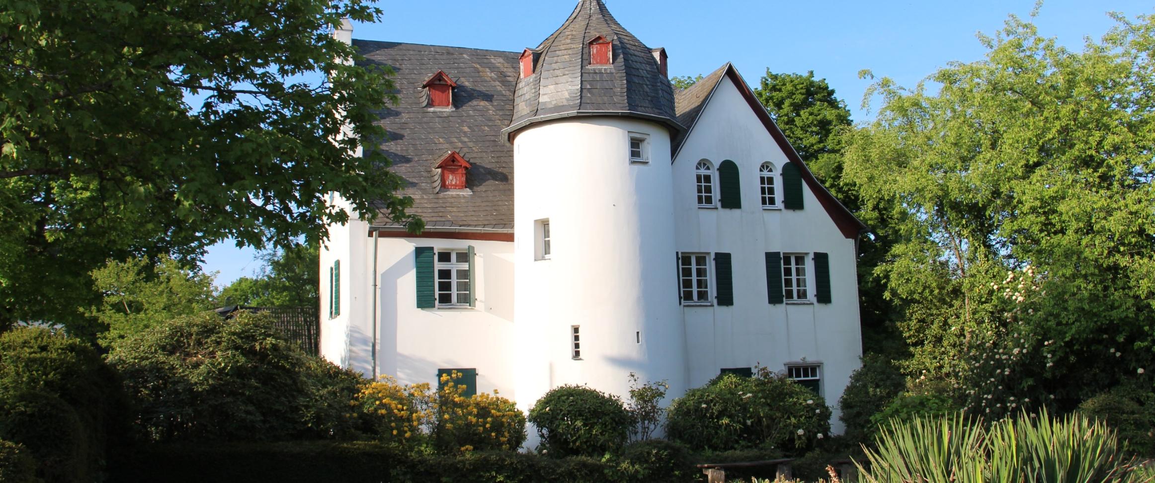 Friedenberger Hof mit Bäumen und blauem Himmel