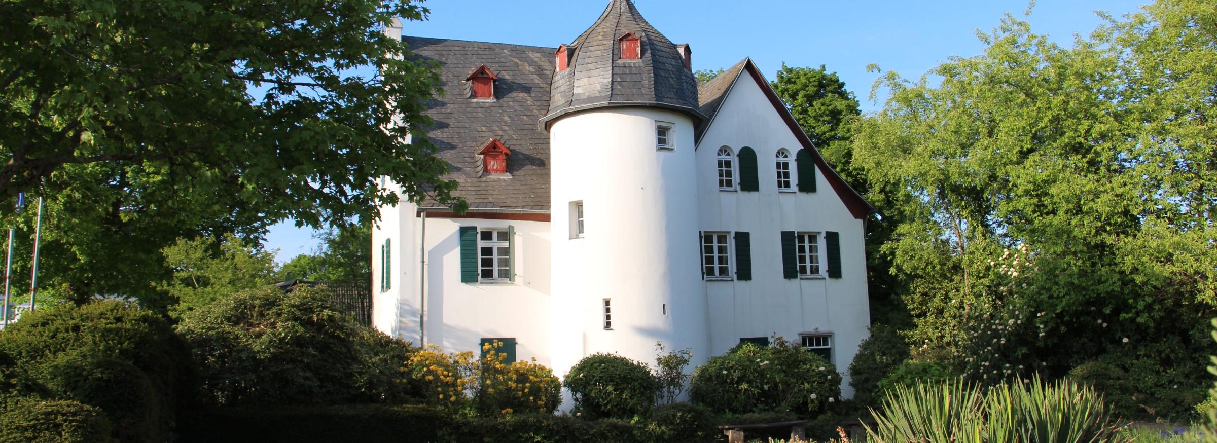 Friedenberger Hof mit Bäumen und blauem Himmel