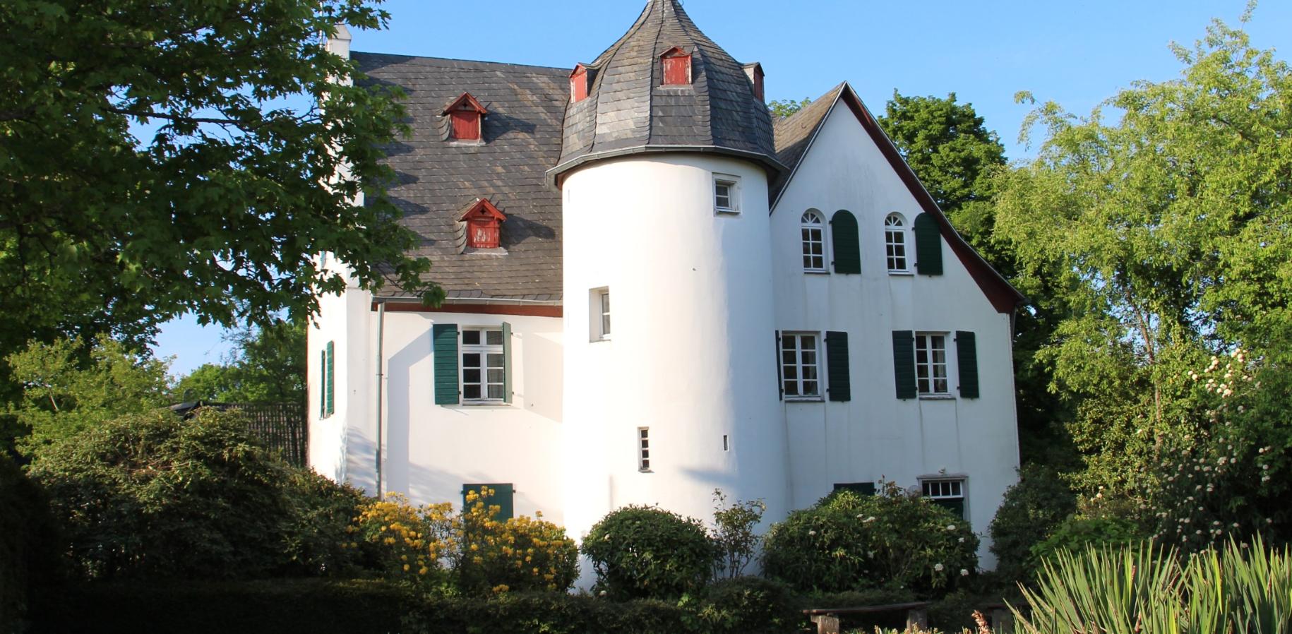 Friedenberger Hof mit Bäumen und blauem Himmel