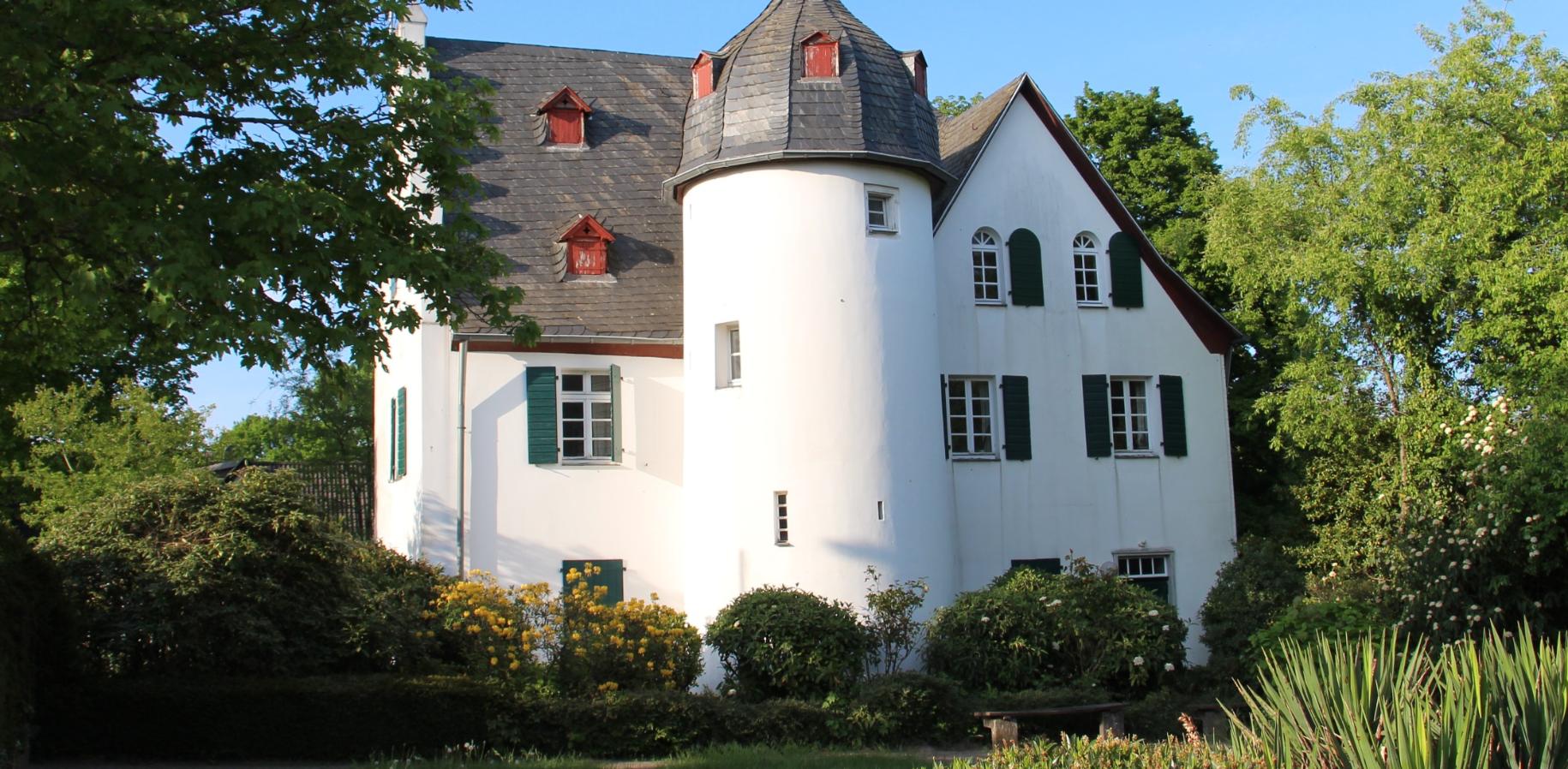 Friedenberger Hof mit Bäumen und blauem Himmel