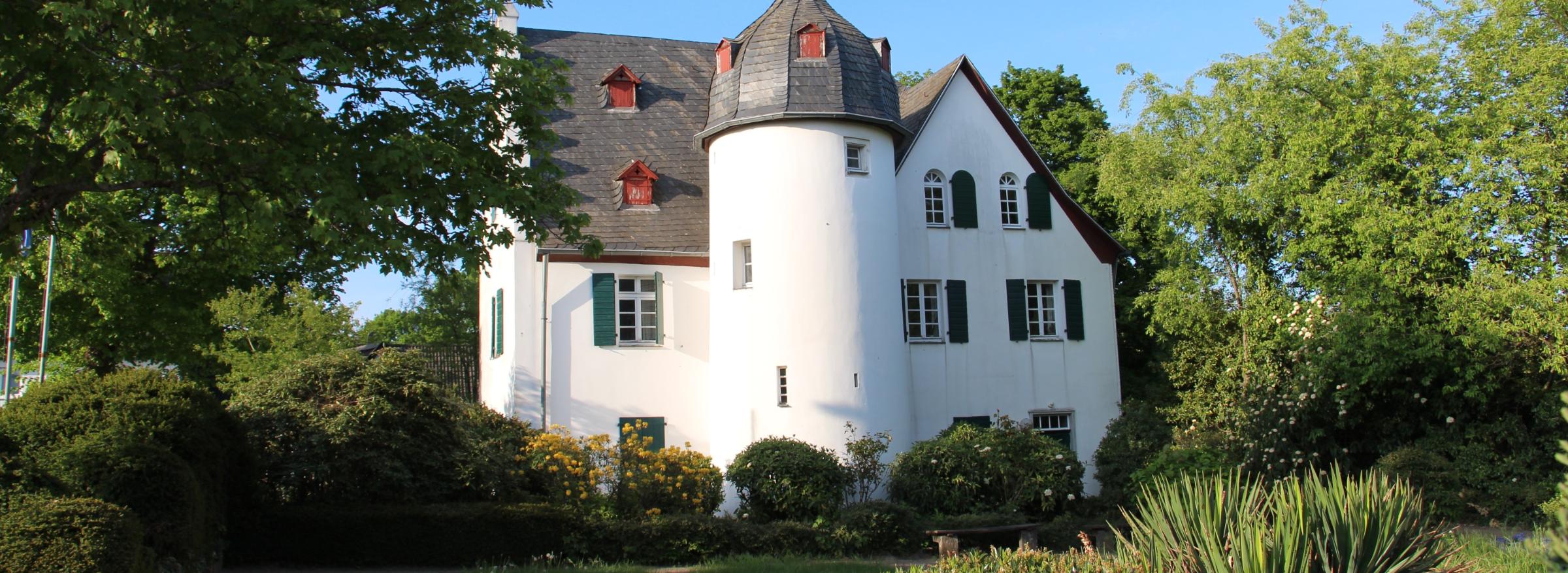 Friedenberger Hof mit Bäumen und blauem Himmel