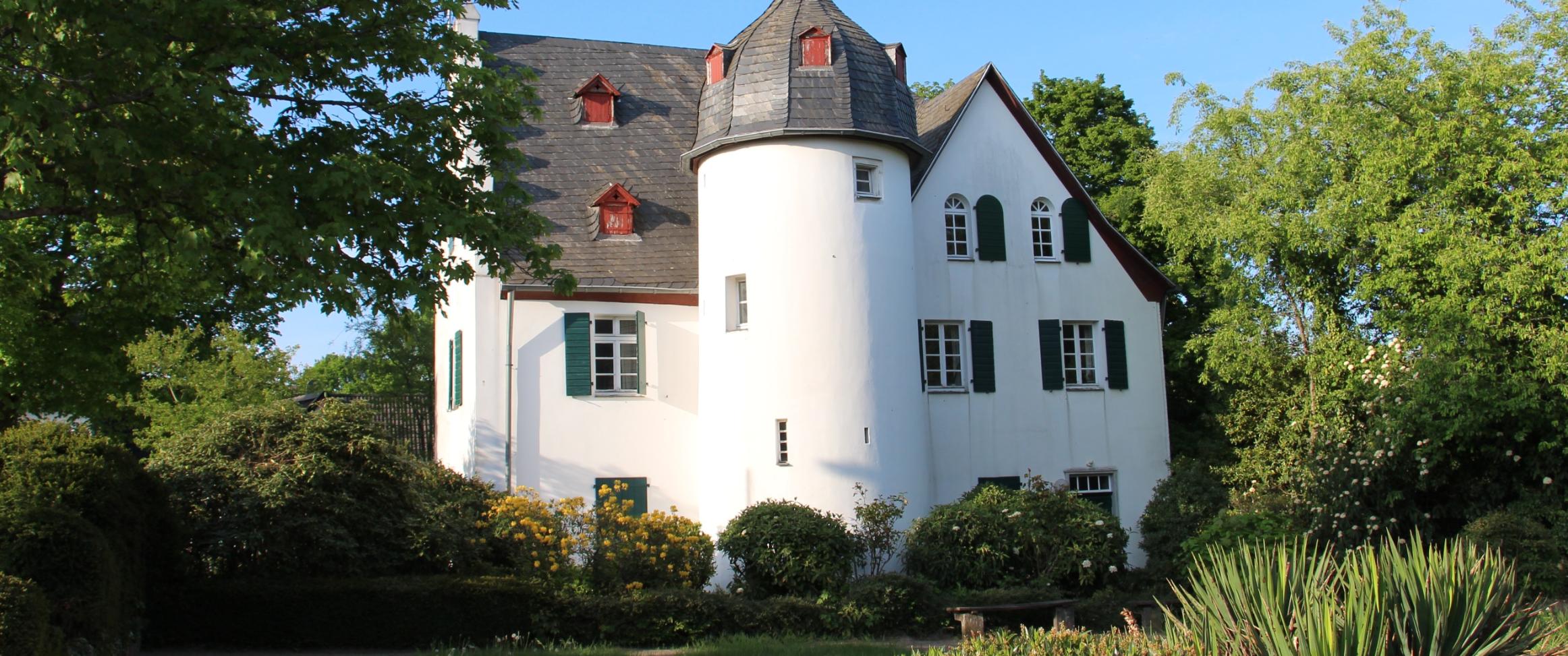 Friedenberger Hof mit Bäumen und blauem Himmel