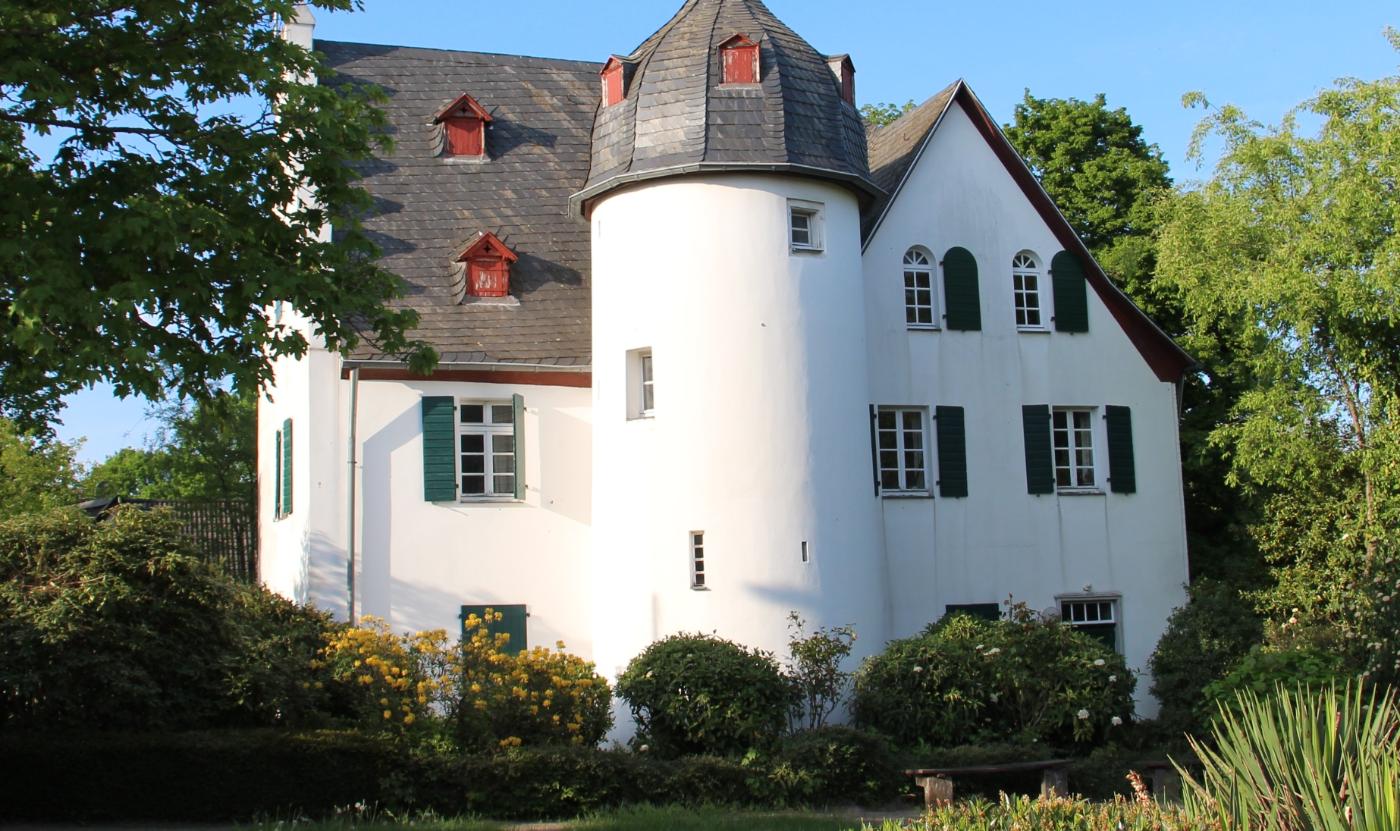 Friedenberger Hof mit Bäumen und blauem Himmel