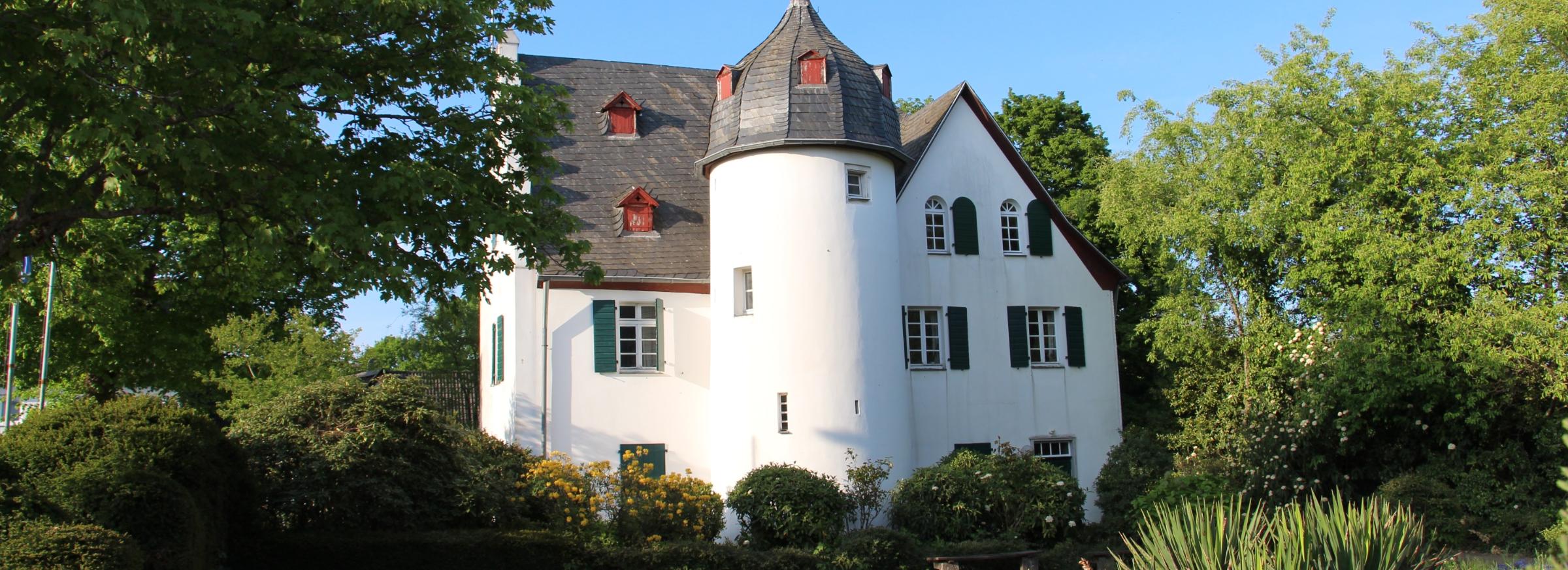 Friedenberger Hof mit Bäumen und blauem Himmel