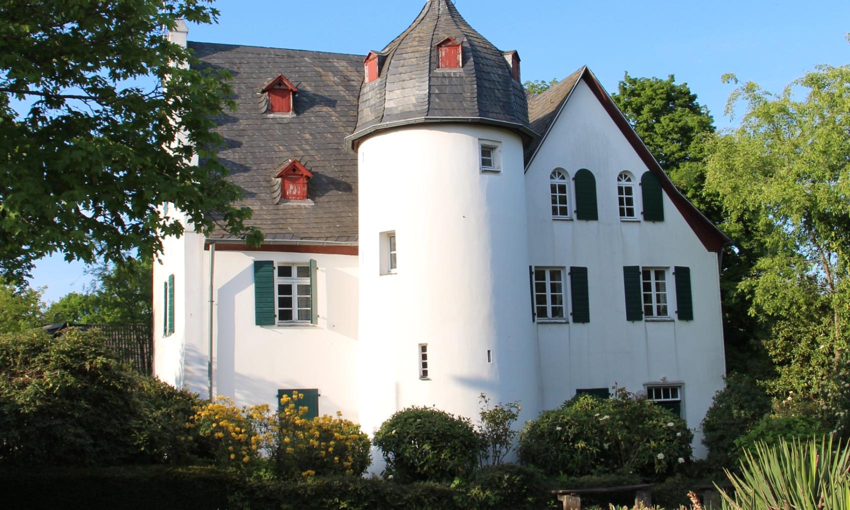 Friedenberger Hof mit Bäumen und blauem Himmel