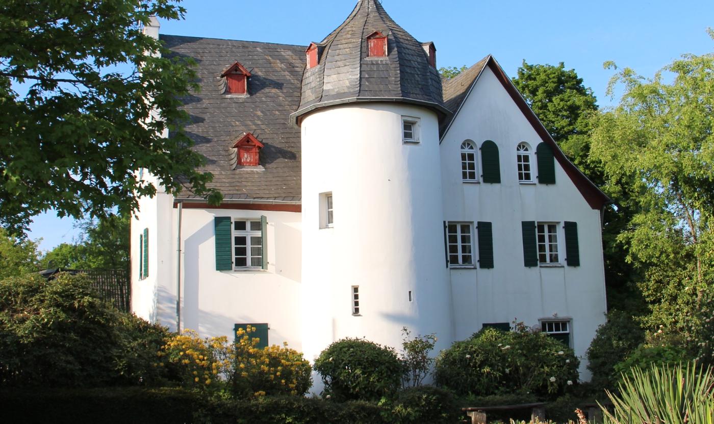 Friedenberger Hof mit Bäumen und blauem Himmel