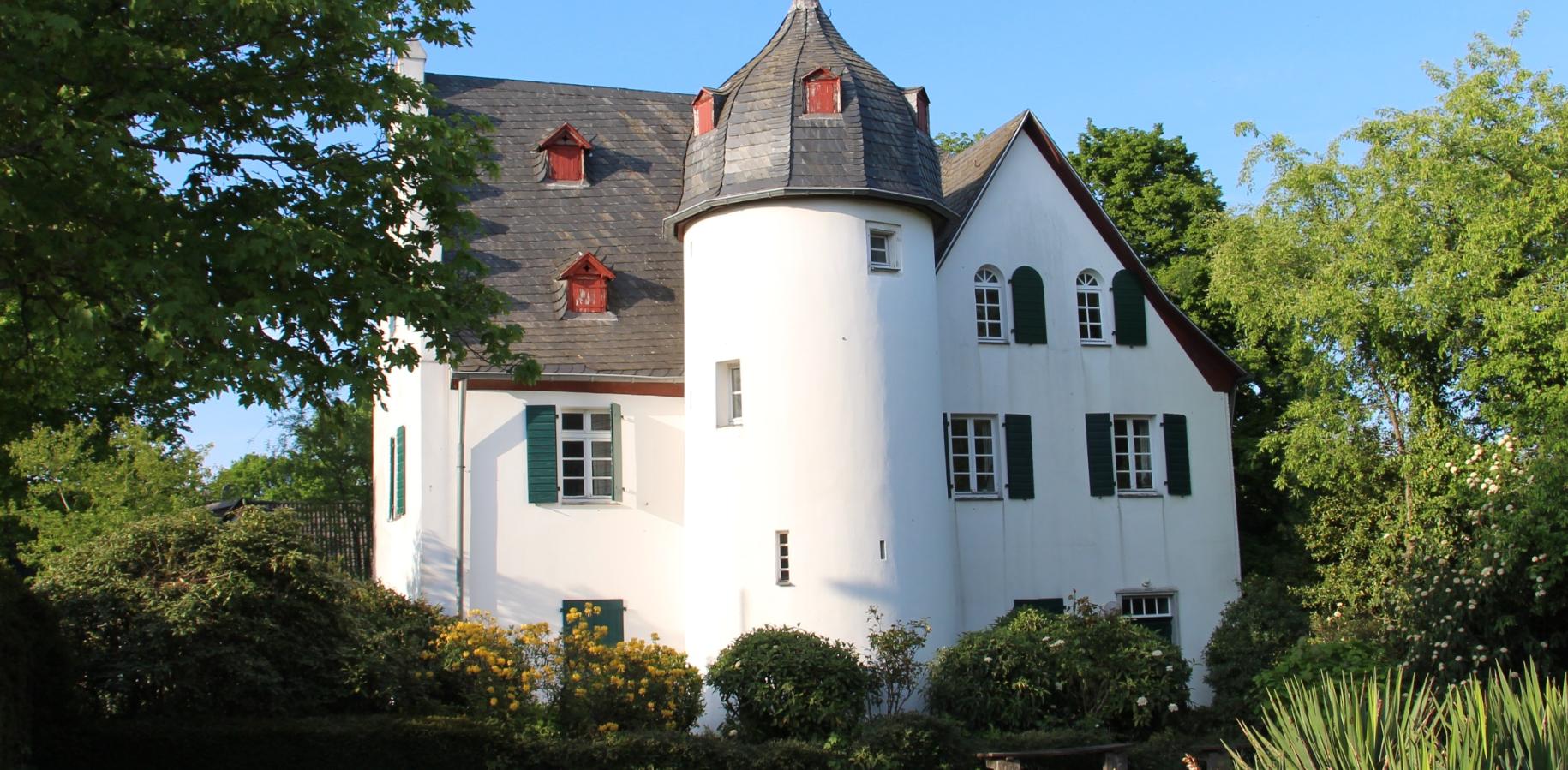 Friedenberger Hof mit Bäumen und blauem Himmel