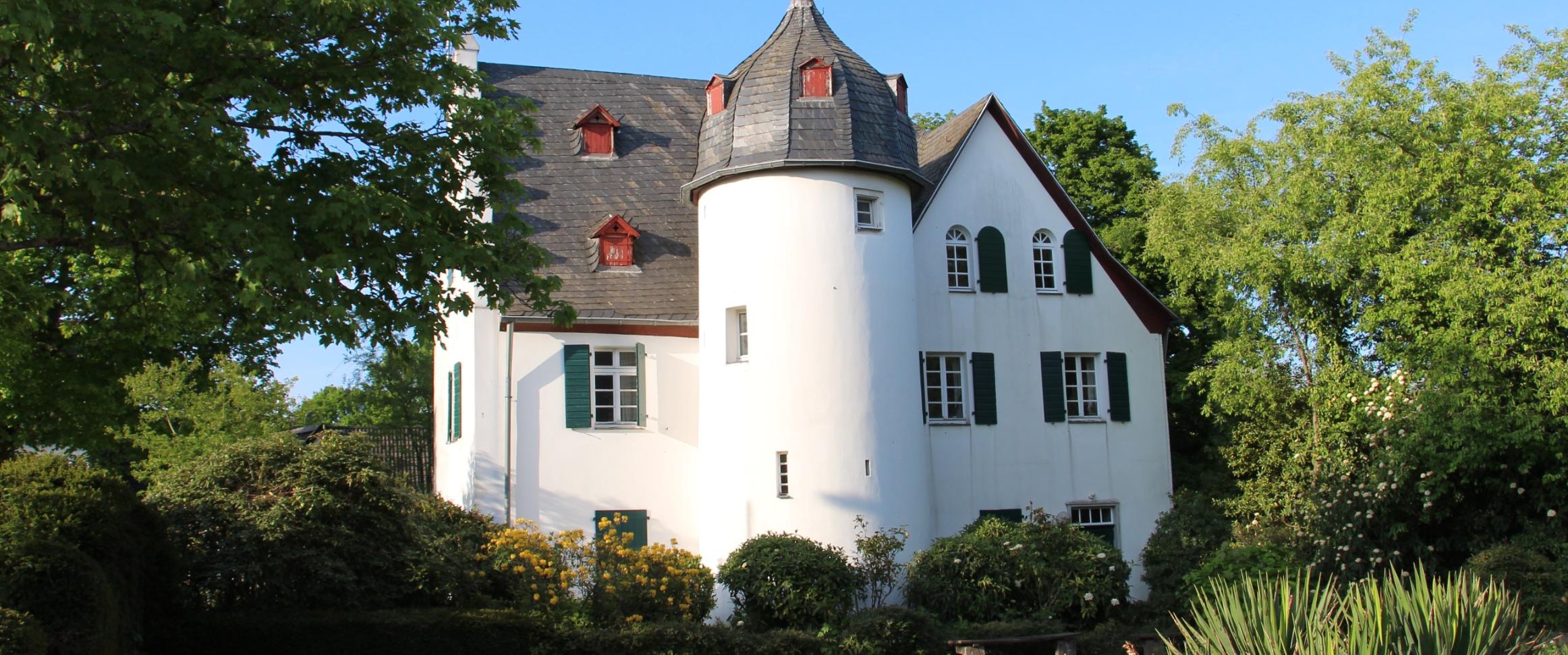 Friedenberger Hof mit Bäumen und blauem Himmel