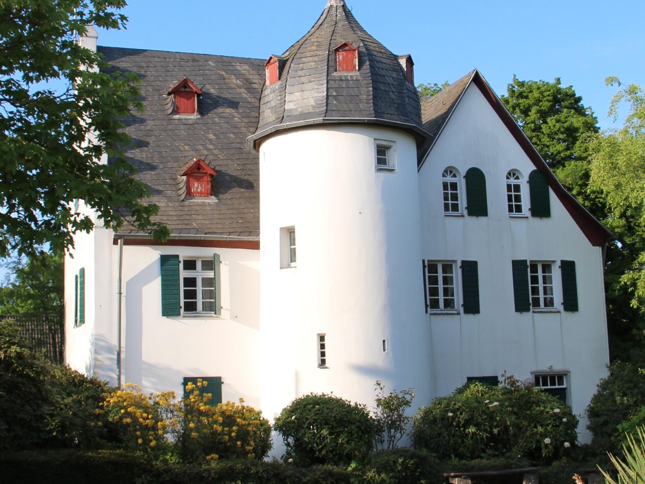 Friedenberger Hof mit Bäumen und blauem Himmel