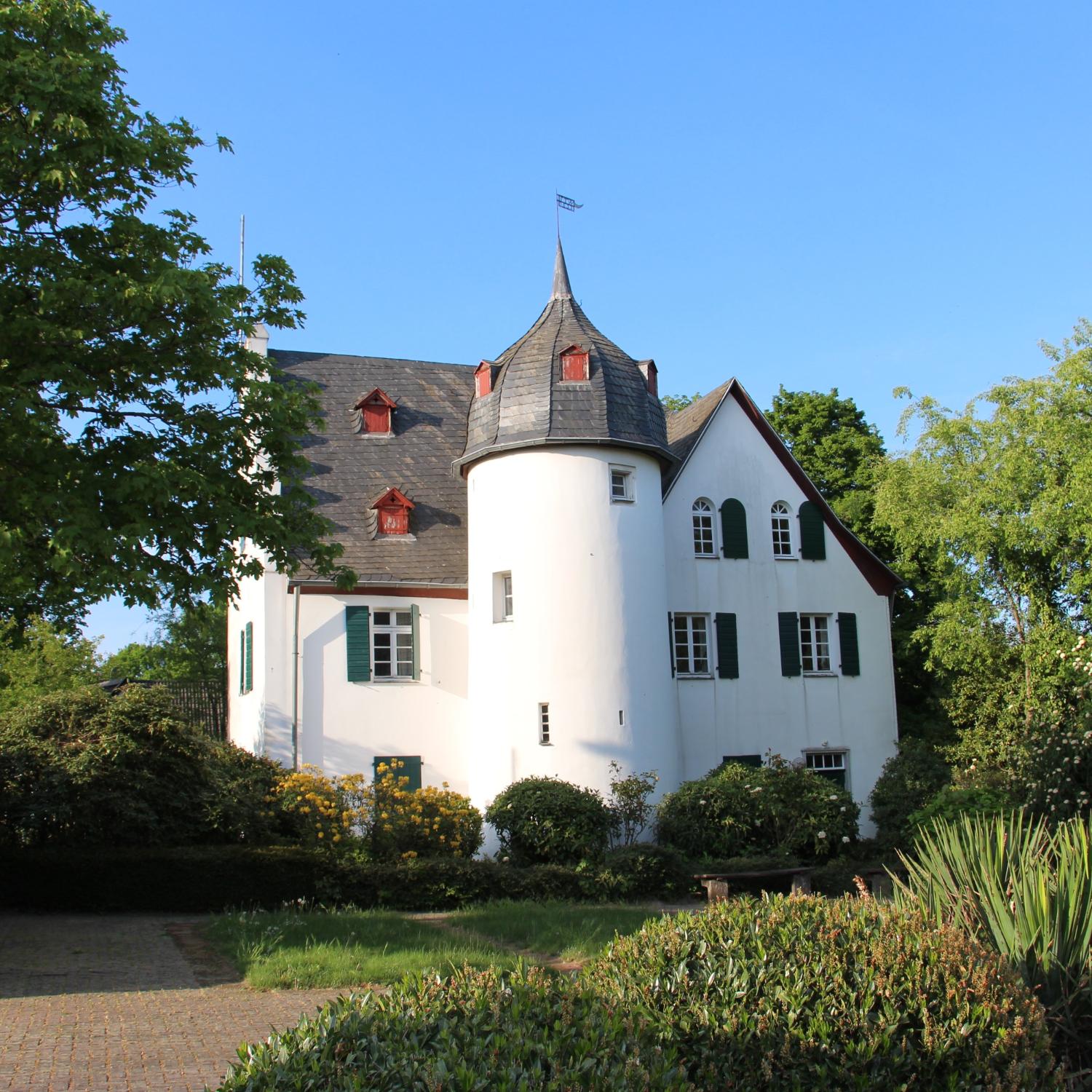 Friedenberger Hof mit Bäumen und blauem Himmel