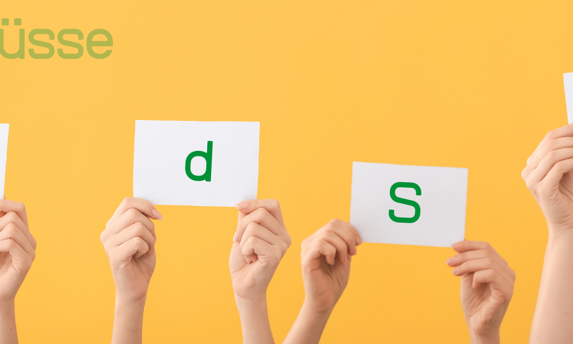 Hände halten Karten mit den Buchstaben B, d, S und J