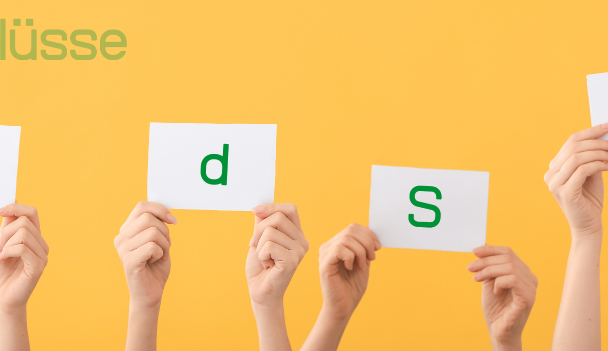 Hände halten Karten mit den Buchstaben B, d, S und J